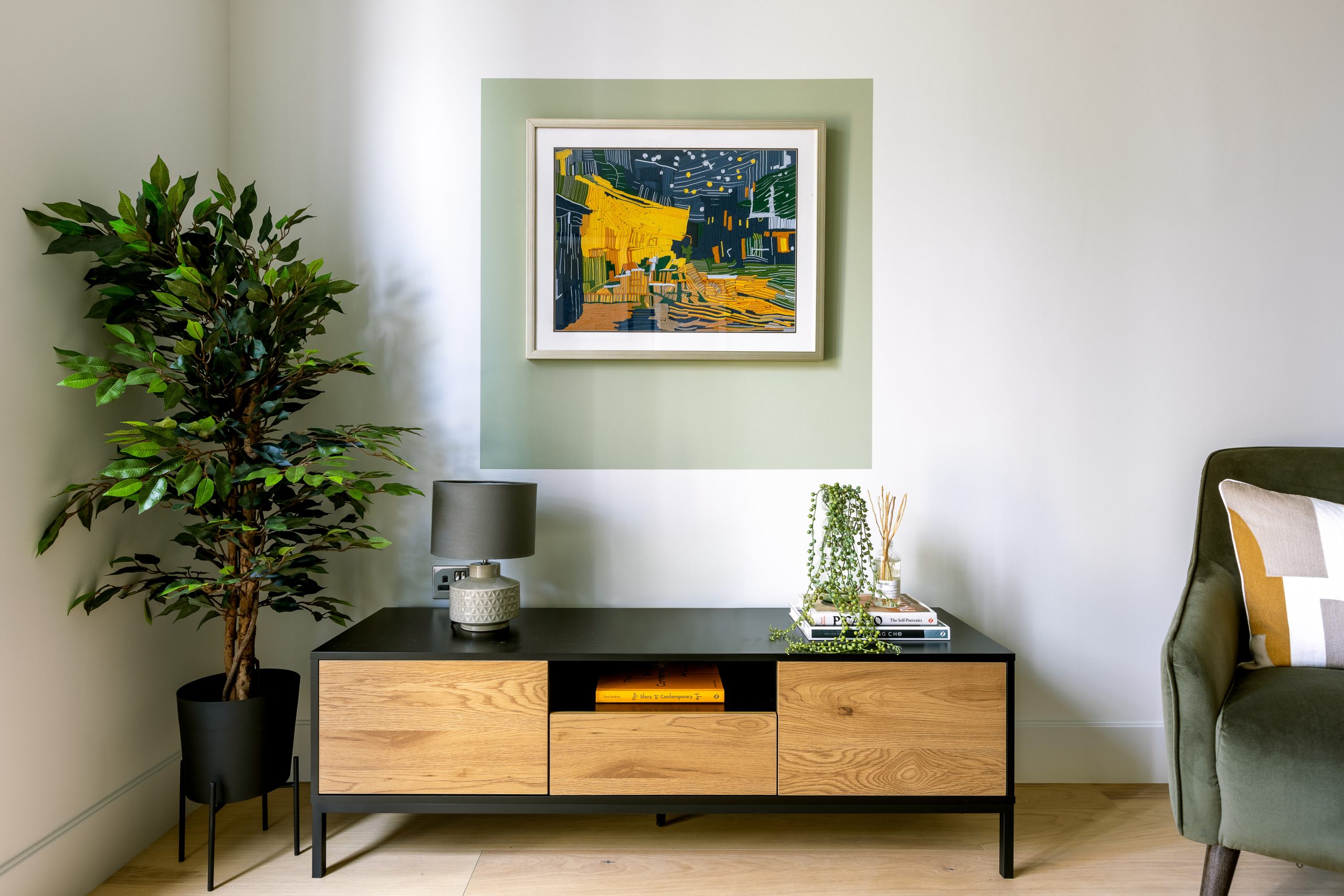 Living room corner with Van Gogh-inspired art and wooden sideboard