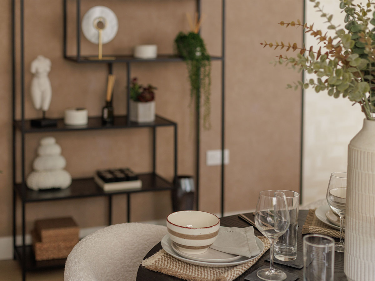 Elegant dining setup with glassware, ceramic bowls, and decorative shelving of Harcourt Gardens