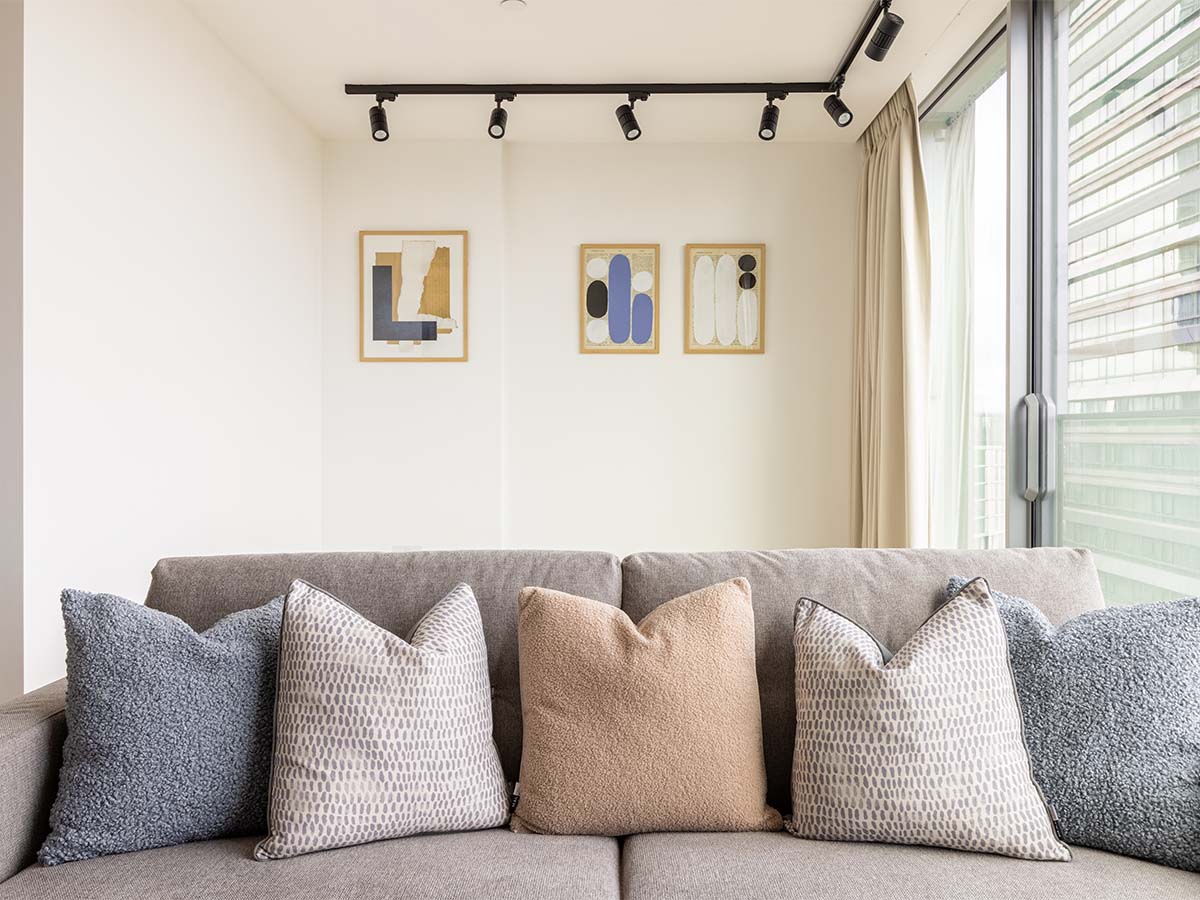 Gray sofa with decorative pillows and framed artwork on the wall of Valencia Tower