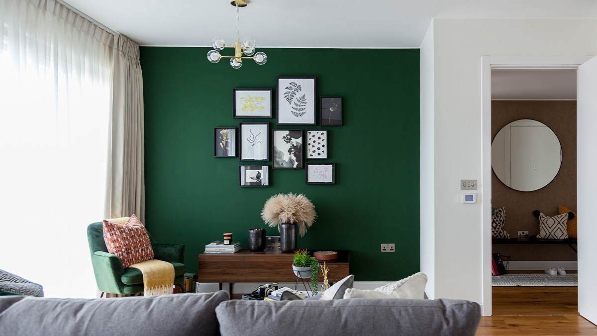 Living room with a green accent wall and framed artwork gallery