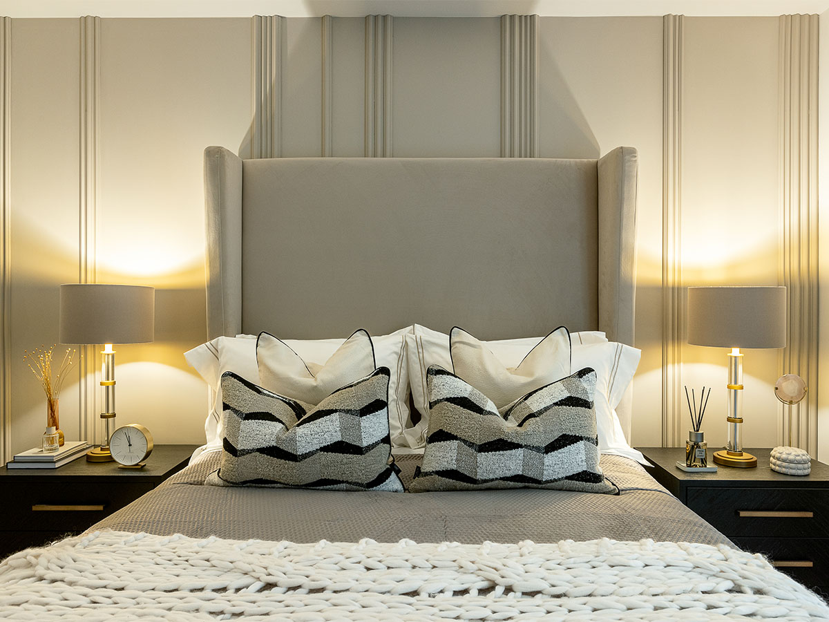 Modern bedroom with neutral tones, layered pillows, and stylish lamps of Verdica_Camden