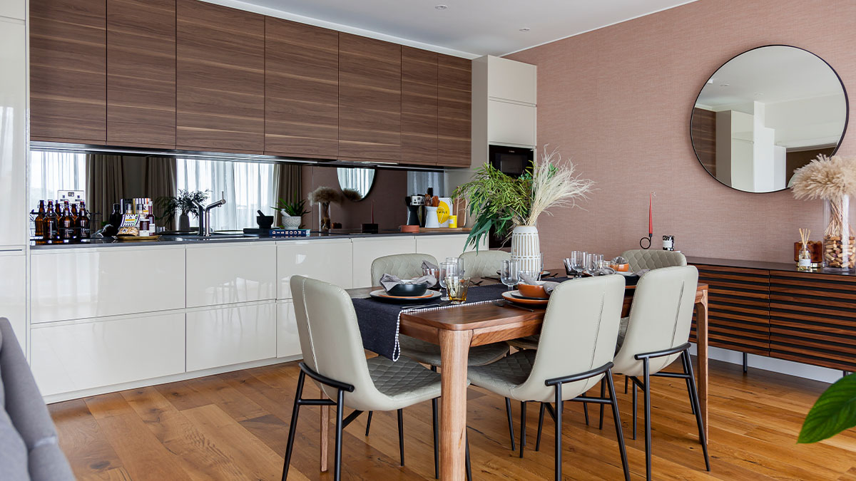 Modern dining area with wooden cabinets and a round mirror on the wall