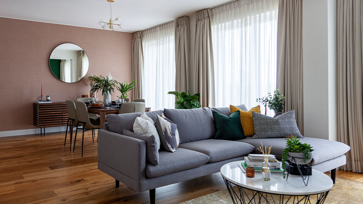 Modern living room with a grey sofa and natural light from large windows