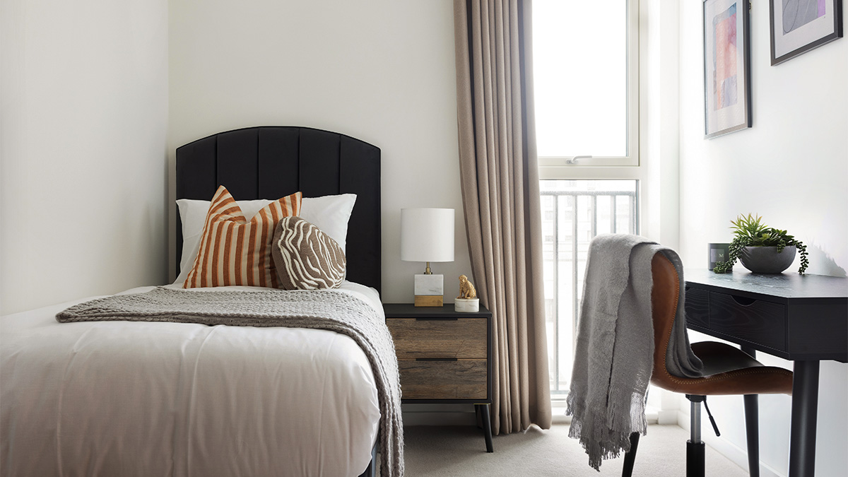 Single bed with side table and workspace in a bedroom