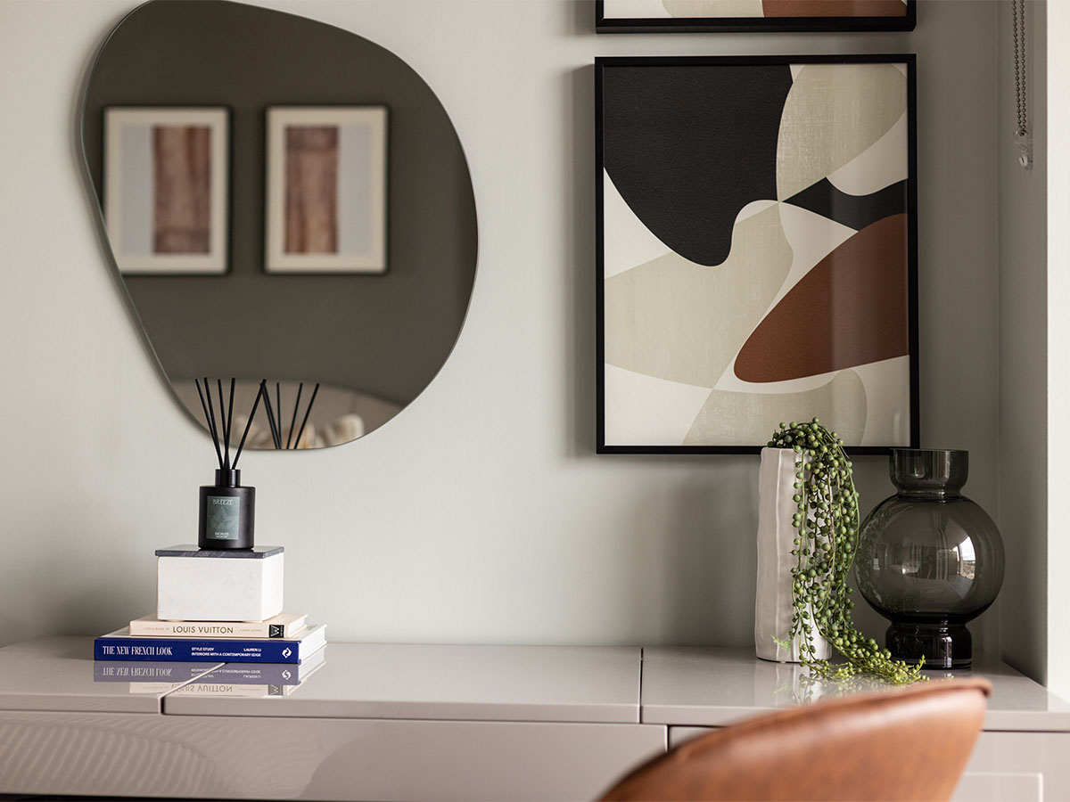 Wall decor, glass vase and books on table top of Coronation Square