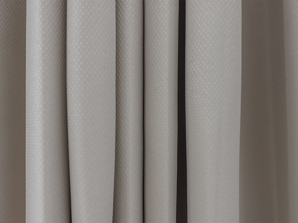 Close-up of textured curtains with a subtle pattern of Beeley