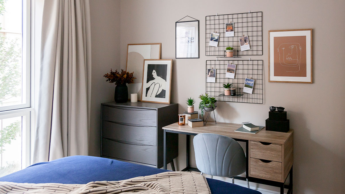 Cozy workspace with wall art, plants, and a desk by a large window