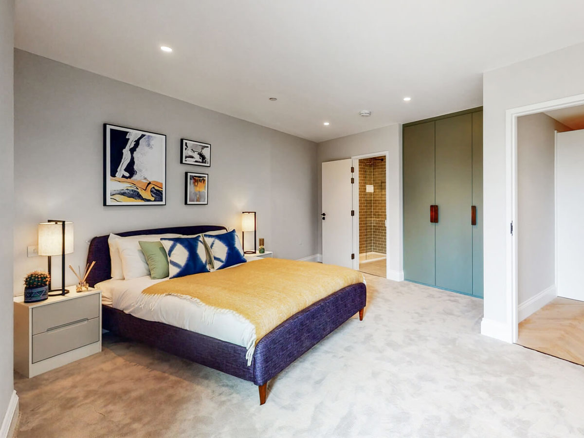 Modern bedroom with a king-size bed, bedside tables, and artwork