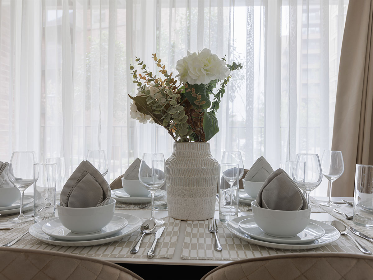 Modern dining table setting with white plates and glassware of Beeley