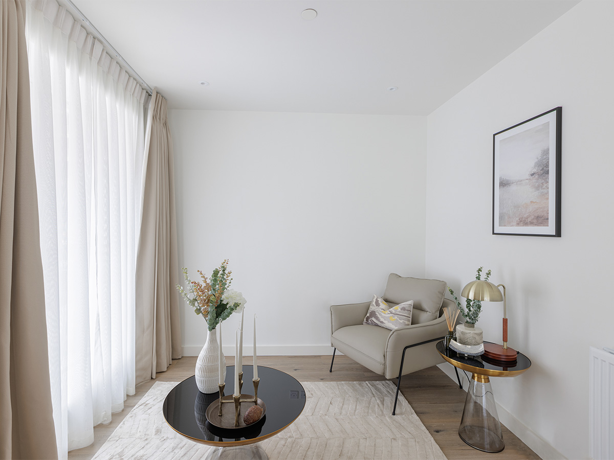 Modern living room with a cozy armchair, coffee table, and artwork of Beeley