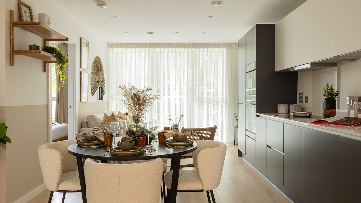 Modern open-plan kitchen and dining area with a round table and chairs of Verdica show flats