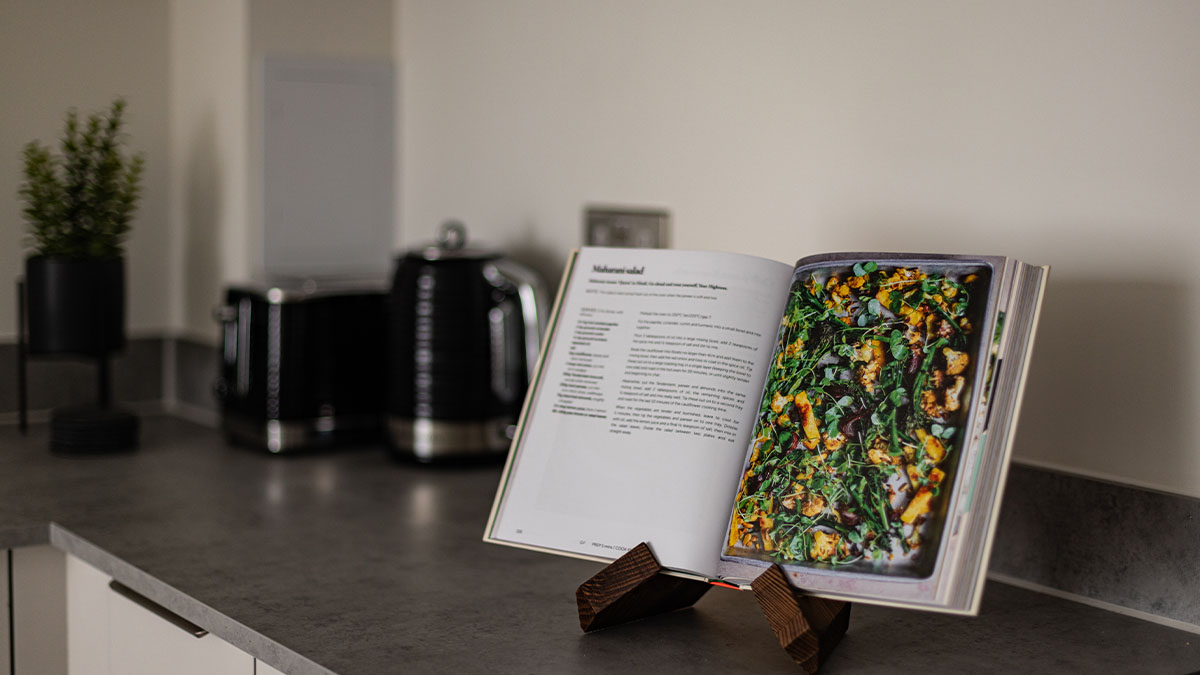 Open cookbook on kitchen counter with recipe for roasted vegetables