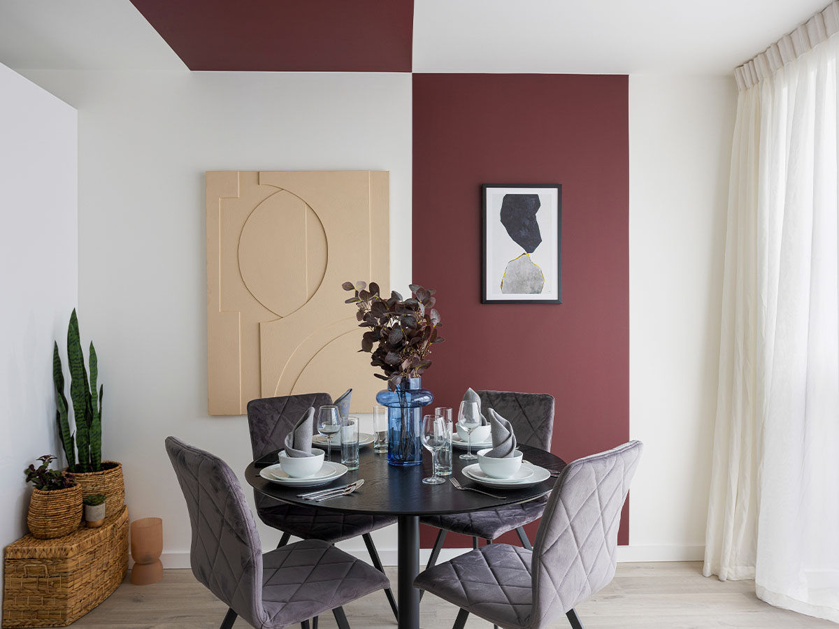 dining room with a round table, chairs, and a feature wall of Cargo House 