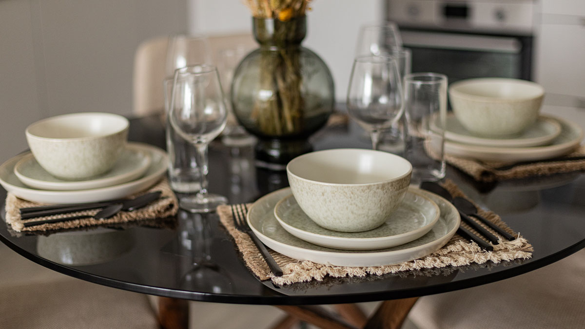 dining table setting with plates, bowls, cutlery, and glassware