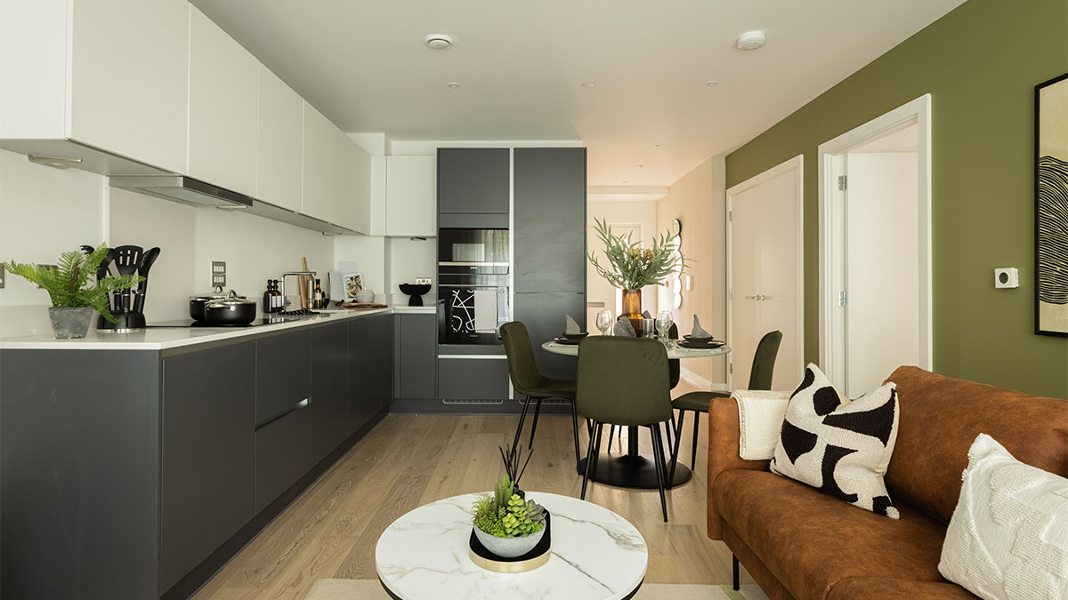 open-plan kitchen and living room with a dining table and sofa of Verdica show flats