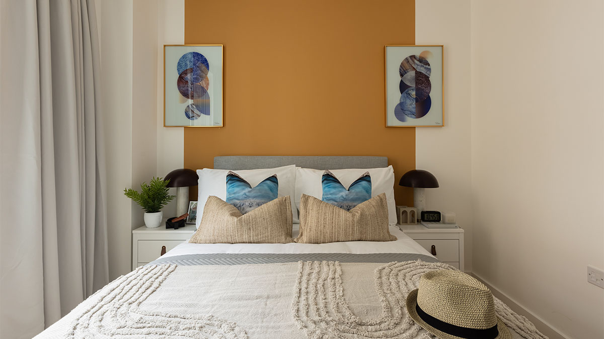 stylish bedroom with a mustard yellow accent wall and a cozy bed of Verdica show flats