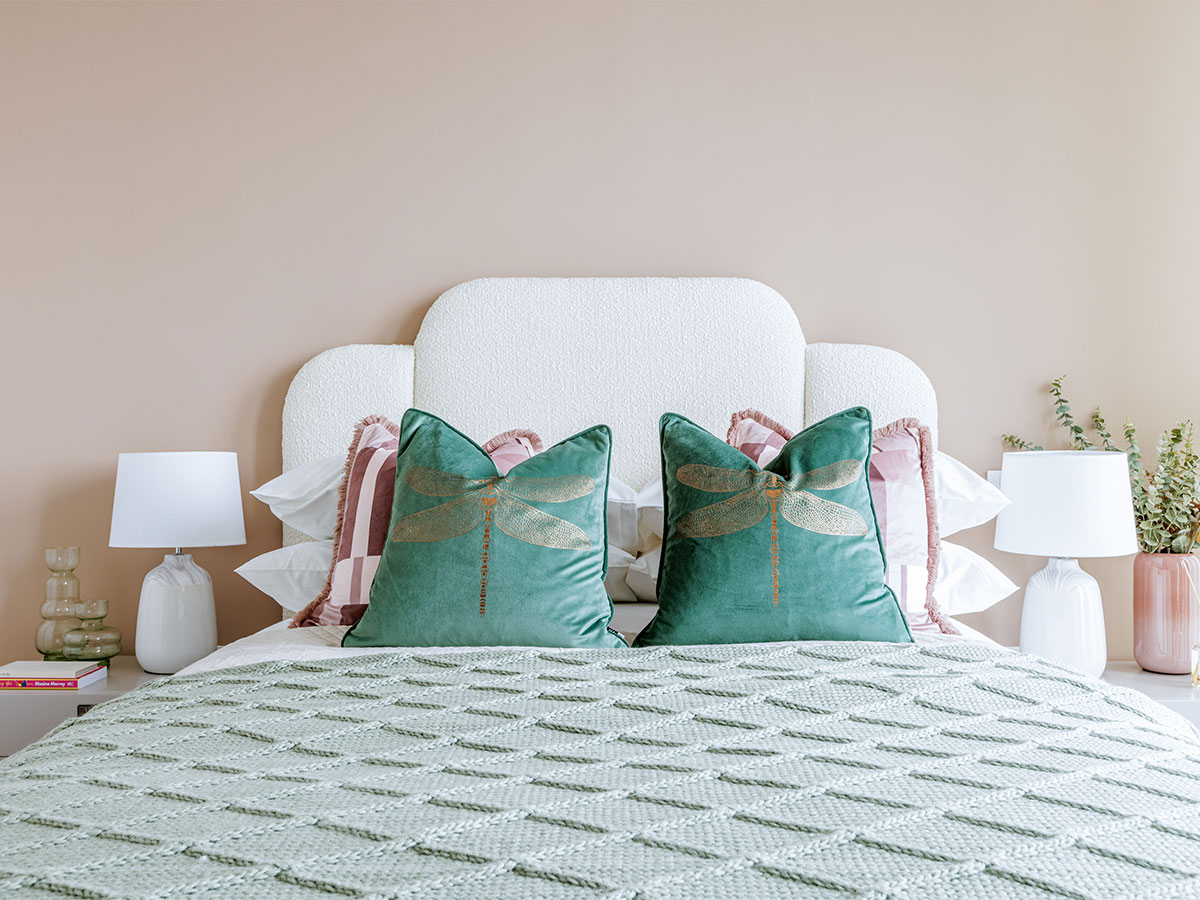 Modern bedroom with pink wall and patterned pillows