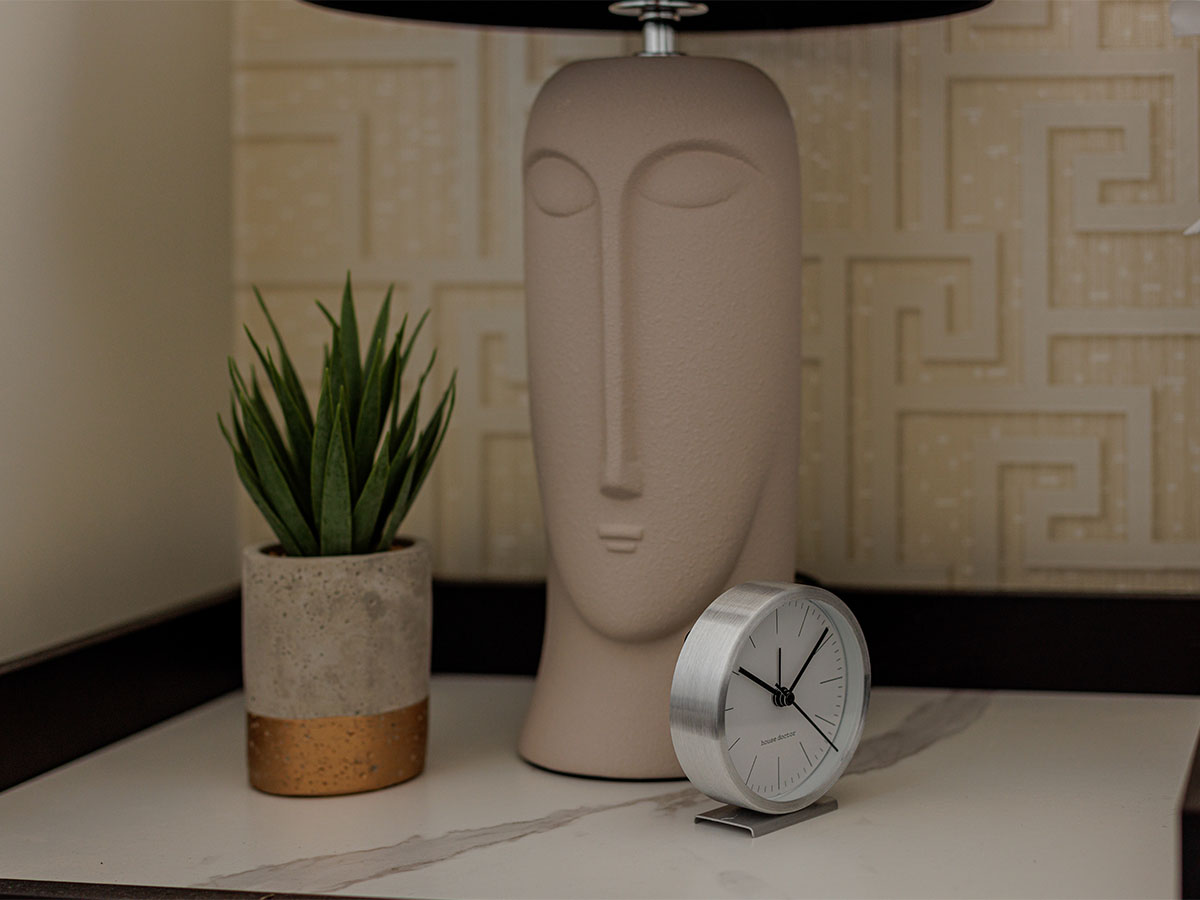 Minimalist bedside table with clock and plant