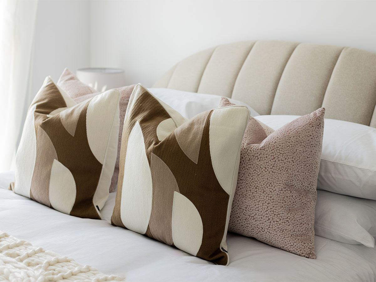 Modern bedroom with decorative pillows on bed