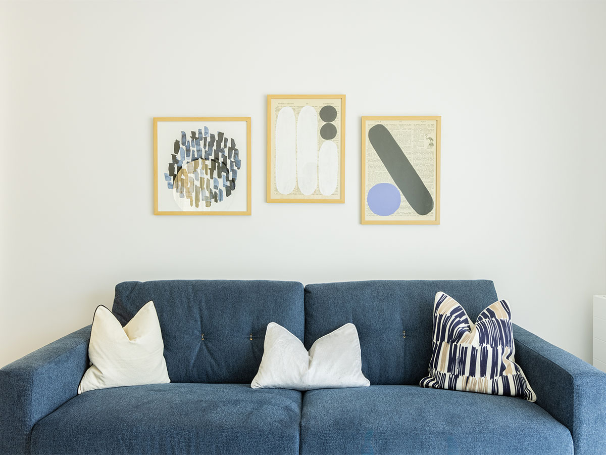 Modern living room with blue sofa and framed art