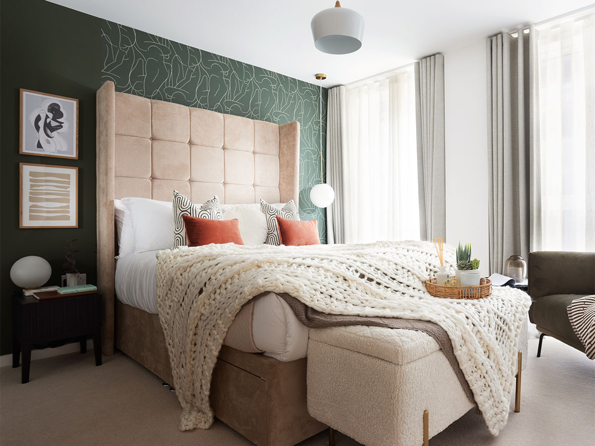 Cozy bedroom with green accent wall and king bed