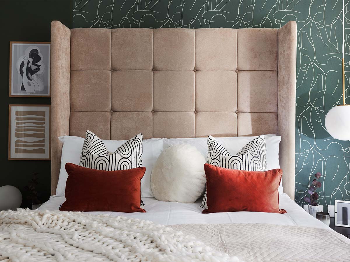 Cozy bedroom with green accent wall and king bed