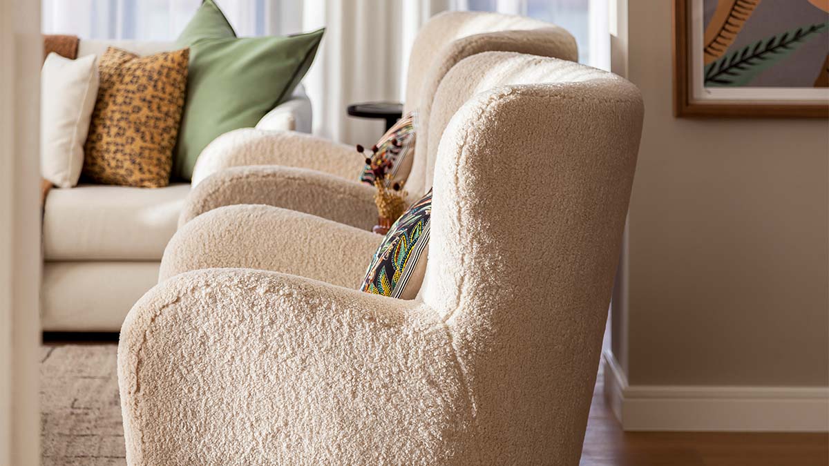 Cozy living room with three plush armchairs in a neutral color