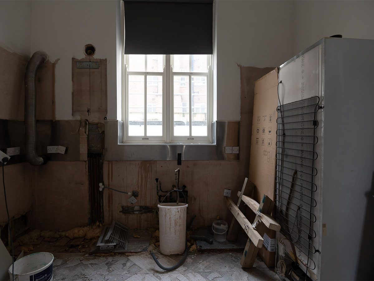 Kitchen renovation with exposed pipes and appliances