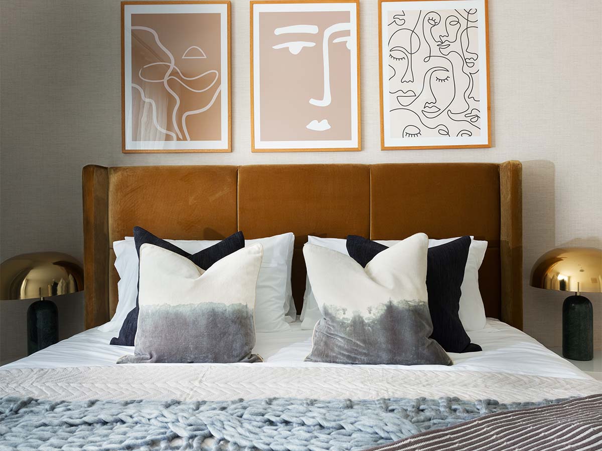 Modern bedroom with abstract art and gold lamps