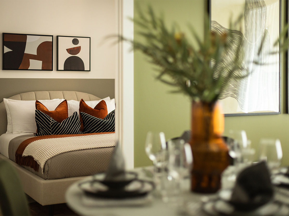 Modern bedroom with green accent wall and dining table