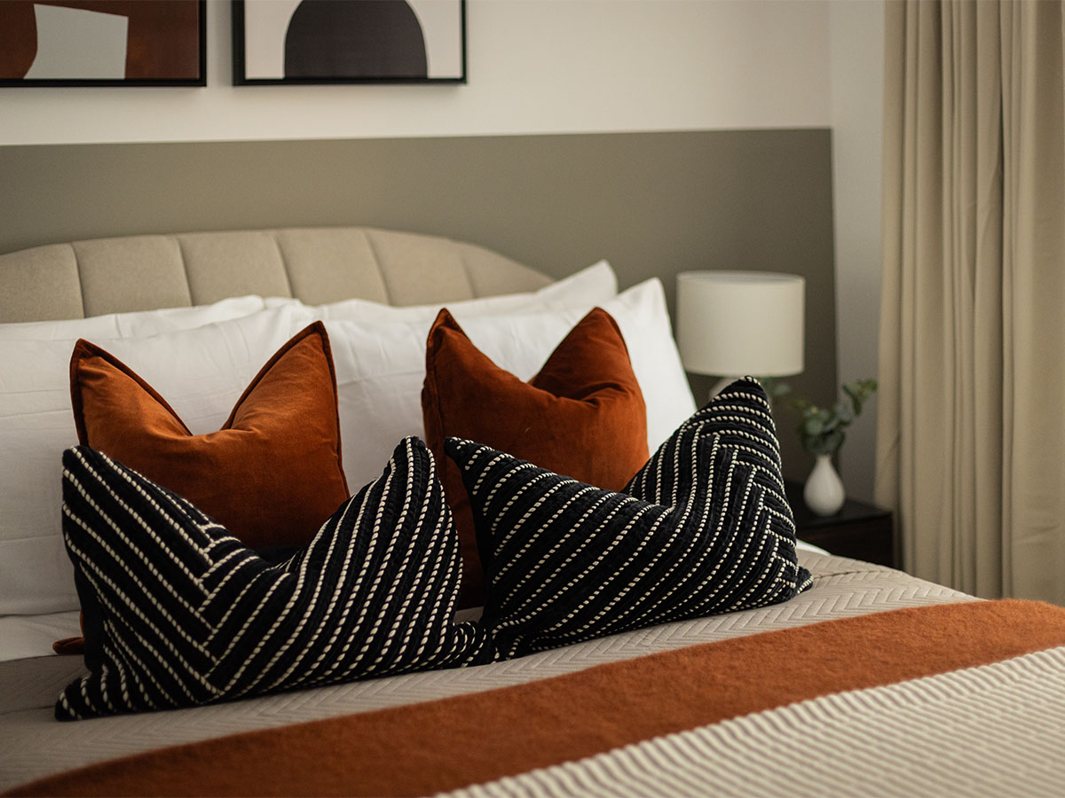 Modern bedroom with textured pillows and warm tones