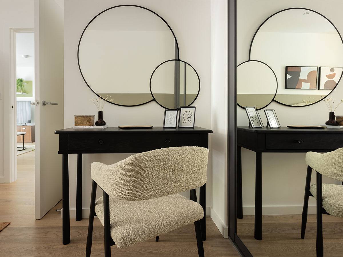 Modern vanity area with circular mirrors and chair