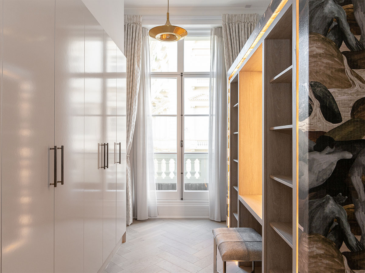 Modern walk-in closet with custom shelving and a window